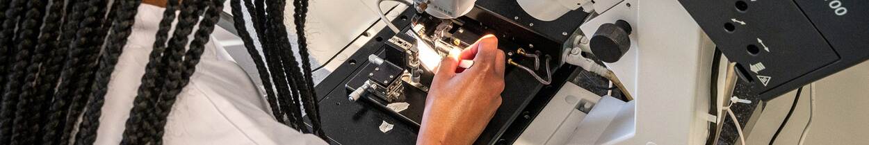 vrouw doet onderzoek met microscoop